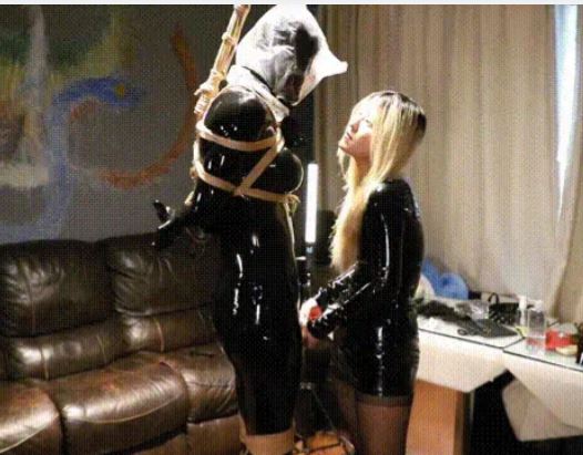 漆皮包臀连衣裙黑丝冷艳黄毛女王强势控制乳胶玩偶。全身被女王捆绑起来直立吊在大厅，胶带全面严格封堵，无法说出任何一句话，再各种培训和呼控的情况下被强制榨汁，受不了也没有任何办法太惨了