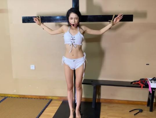 曼曼穿着性感牛仔套装，三角牛仔裤可以隐隐约约看出形状哦，被绑在十字架上，蒙上眼罩，被迫戴上口球流口水